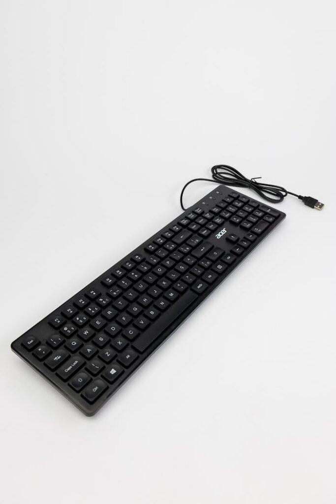 Computer Keyboard with a Cable on a Plain Background